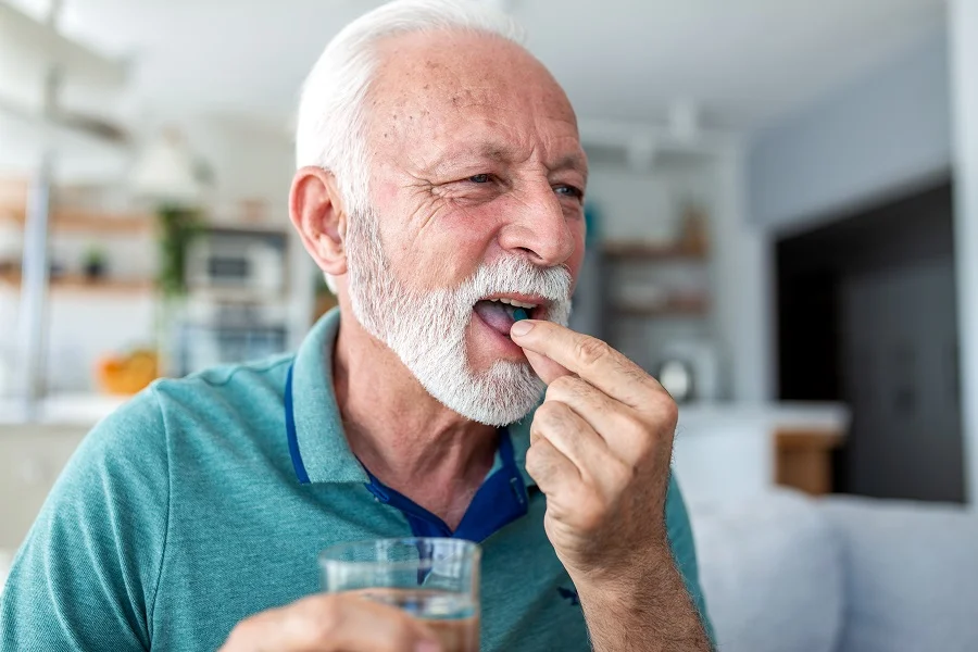 Elderly man taking supplements